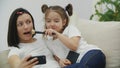 4k video of mommy and kid having fun with phone at home.