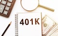 401k written on notebook with dollars, calculator, pen and magnifier. Savings concept