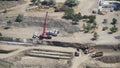 8K Red crane carries concrete pipe at construction site