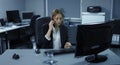 4K: A young employee sits tensely in her office. A telephone call disturbs her computer work.