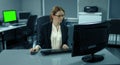 4K: A young manager is working very concentrated at her desk. She is typing on a computer keyboard.