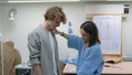 4K. A young woman seamstress works with a client in a sewing workshop, she takes measurements with a measuring tape Royalty Free Stock Photo