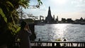 4K Young woman traveler traveling into Wat Arun Ratchawararam Ratchawaramahawihan temple in Bangkok