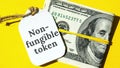 4k zoom in out NFT non-fungible token text. Concept words NFT non-fungible token on paper blank. Background of dollar