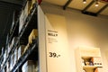 View on aisle with high metal shelves in self service storage of Swedish furniture store IKEA. Shelf contains famous bookshelf BIL