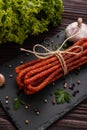 Kabanos delicious polish snack sausage on a stone plate wooden background