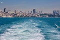 Seagulls fly over the sea behind the boat. Ships wake. The ship is leaving the big city. Royalty Free Stock Photo