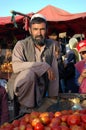Kabul, Afghanistan: An Afghan man with a black beard sells tomatoes at the market