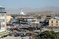 A view of central Kabul, Afghanistan showing the market, mosque, crowds of people and distant hills.