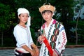 Kachin or Jingpo people in traditional clothes wear traditional wicker hats with wild boar tusks. A woman wears a white headdress. Royalty Free Stock Photo