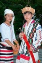 Kachin or Jingpo people in traditional clothes wear traditional wicker hats with wild boar tusks. A woman wears a white headdress. Royalty Free Stock Photo