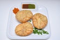 Kachori with dry garlic chutney garnished with coriander leaves kachori is a spicy snack from India also spelled as kachauri