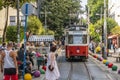 Noltalgic tram in kadikoy district with people and modern buildings.