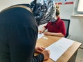 Muslim Turkish adult woman signing official approval document for corona virus covid 19 vaccination in a hospital room