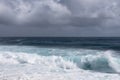 Azure wave turns into white surf under heavy cloudscape on Kaimu Beach, Hawaii, USA Royalty Free Stock Photo