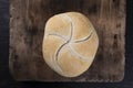 The Kaiser bread roll. A crusty round bread roll on a wooden cutting board Royalty Free Stock Photo