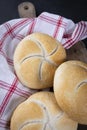 The Kaiser bread rolls. A crusty round bread rolls on a linen kitchen cloth and a wooden cutting board Royalty Free Stock Photo