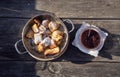 Kaiserschmarrn served in a pan with plum compote on an old wooden table