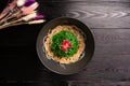 Kaiso with nut sauce and sesame in a black plate on a wooden background