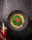 Kaiso with nut sauce and sesame in a black plate on a wooden background