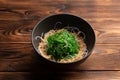 Kaiso with nut sauce and sesame on a wooden background