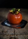 Kaki fruit / persimmon with droplets on metal dish