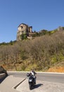 Kalabaka, Greece. April 2022: Motorcyclist and view of the Meteora Mountains and the Rusanou Monastery from the observation deck