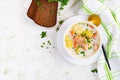 Creamy soup with salmon, potatoes, onions and carrots and in a bowl.