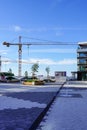 Modern district with new buildings. Building yellow cranes on the back.