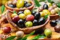 Kalamata, green and black olives in the wooden plate. Food background