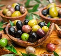 Kalamata, green and black olives in the wooden plates. Food background