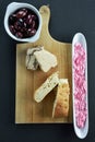 Kalamon olives on bowl, sunflower halva and lagana bread on cutting board and olive dish with taramosalata