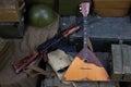 Kalashnikov AK 47 with ammunitions and balalaika on army box background