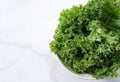 Kale in bowl on marble background. curly kale