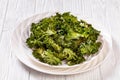 White plate with kale chips on the table Royalty Free Stock Photo