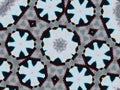 Kaleidoscope pattern with polygon and flower-shaped figures in white and dark blue colors