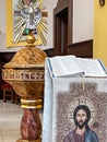 Kalety, Poland, May 13, 2023: Baptismal font with a dove symbolizing the Holy Spirit and a stand with the Holy Bible in the church