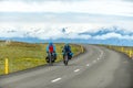 Two cyclists ride a touring bike on an Icelandic rural highway Royalty Free Stock Photo