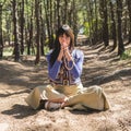 Kali mudra executed in lotus position by a woman while she looks at camera. Nature background