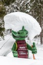Kali the Ramsaurier, likeable, snow covered, green dinosaur mascot of ski school at ski region Ramsau Dachstein, Steiermark.