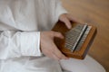 Kalimba in the hands of a young woman musician in white clothes