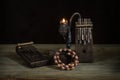 A Kalimba musical instrument made of dark wood with a geometric pattern, a candle holder with a burning candle and an African wome