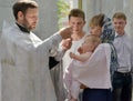 KALININGRAD, RUSSIA. An Orthodox priest puts a cross on an infant. Baptism rite