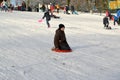 KALININGRAD, RUSSIA.The boy goes from a hill on the plastic sledge Royalty Free Stock Photo