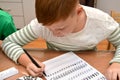 KALININGRAD, RUSSIA. The boy writes letters with calligraphical handwriting Royalty Free Stock Photo