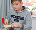 A boy drill holes in a wooden bar. Wood Processing Master Class