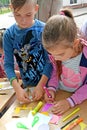 The boy and the girl are engaged in applique from color paper. Children`s master class in the open air