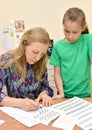 KALININGRAD, RUSSIA. The teacher shows to the girl writing of letters. A calligraphy lesson in children`s studio Royalty Free Stock Photo