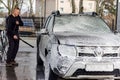 The SUV at the car wash. A man washes his car at a touchless car wash. Washing his brown Renault car