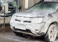 The SUV at the car wash. A man washes his car at a touchless car wash. Washing his brown Renault car